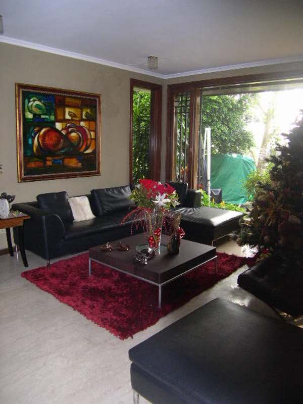 Elegant spacious living room with marble floor, glass doors overlooking lush garden at Dos Mares Panama