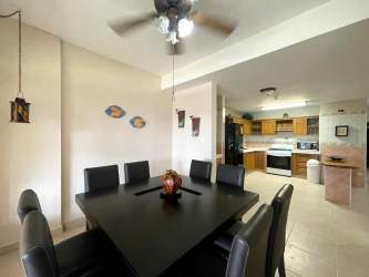 Dining area with black furniture open plan to kitchen modern beach house Playa Blanca