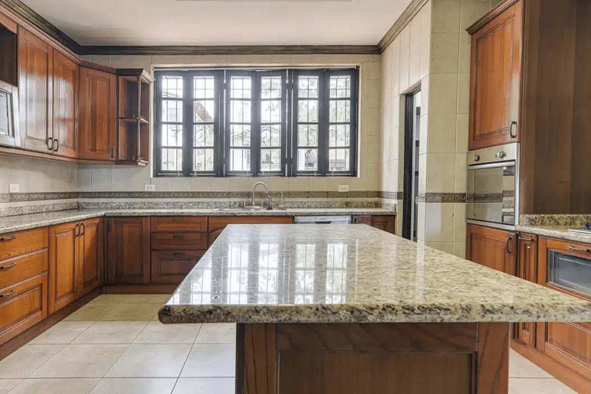 Custom kitchen with granite countertops, wood cabinetry, large island in Hato Pintado Panama City