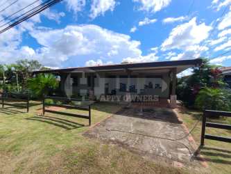 Front view single-level house with covered porch fenced yard drive and garden in Chitré Panama