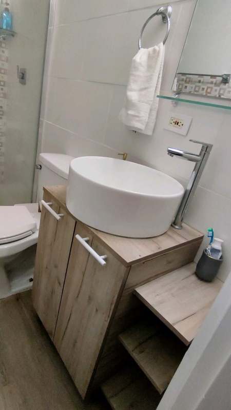 Bright hallway with mirror, light blue walls and wood-look flooring in Bella Vista condo Panama