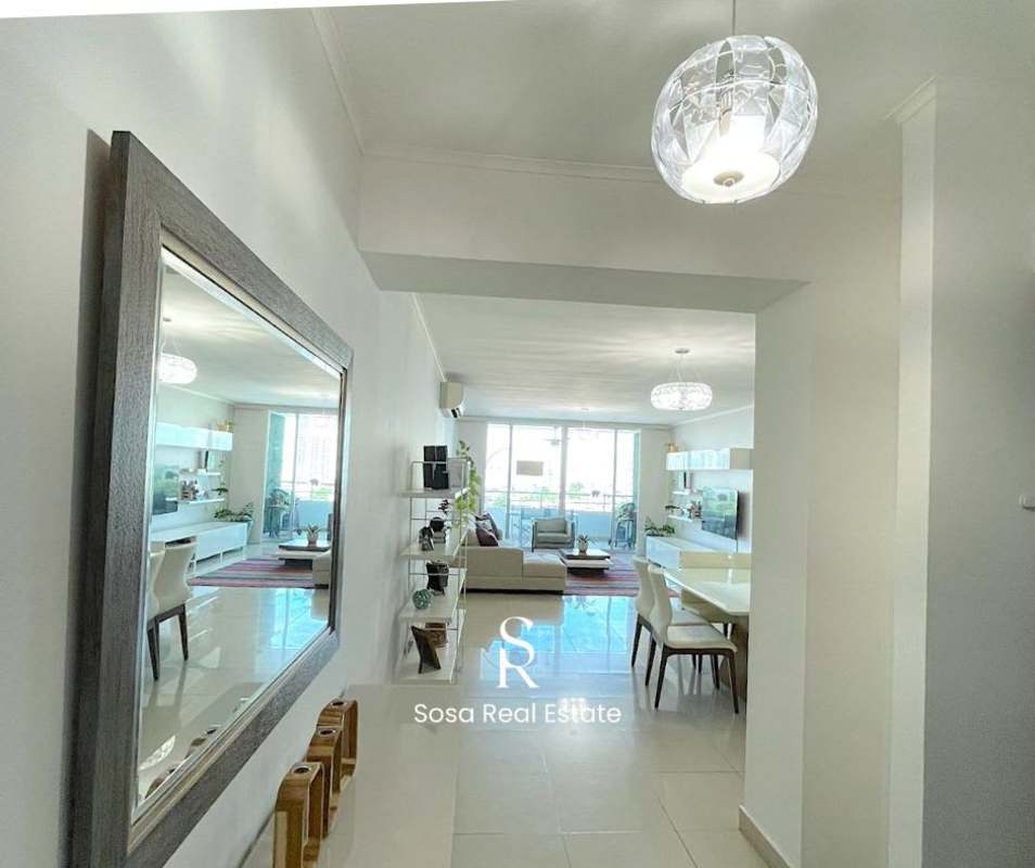 Dining area with mirrored wall and pendant lights in modern apartment near Parque Omar Panama City