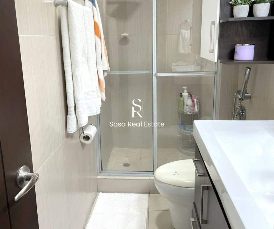 Modern bathroom with glass-enclosed shower, beige tiles and vanity in San Francisco apartment Panama