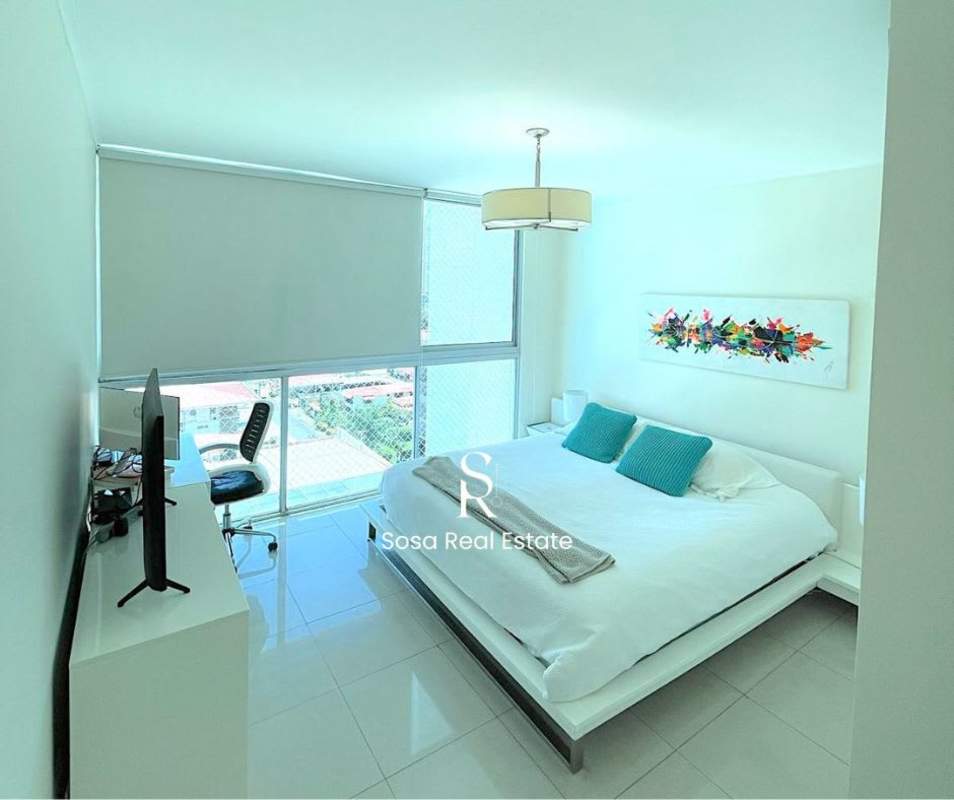 Minimalist bedroom with large windows, platform bed and abstract art in Panama City condo