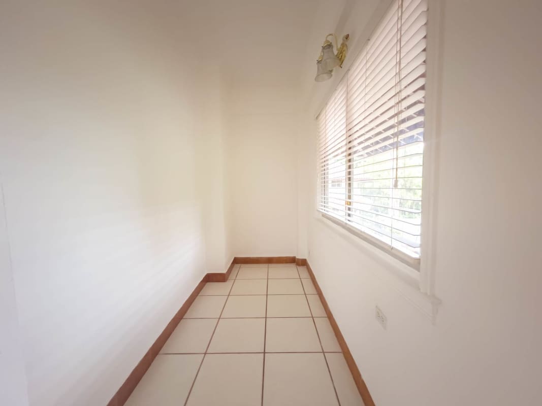 Bright bedroom space with large window, garden views, ceiling fan Panama