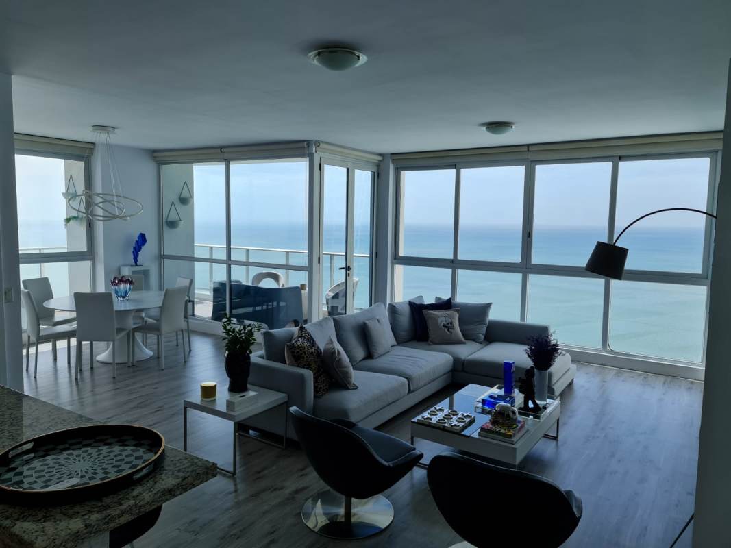 Open plan living dining room with floor-to-ceiling windows overlooking the ocean in PH Oceanaire Panama City