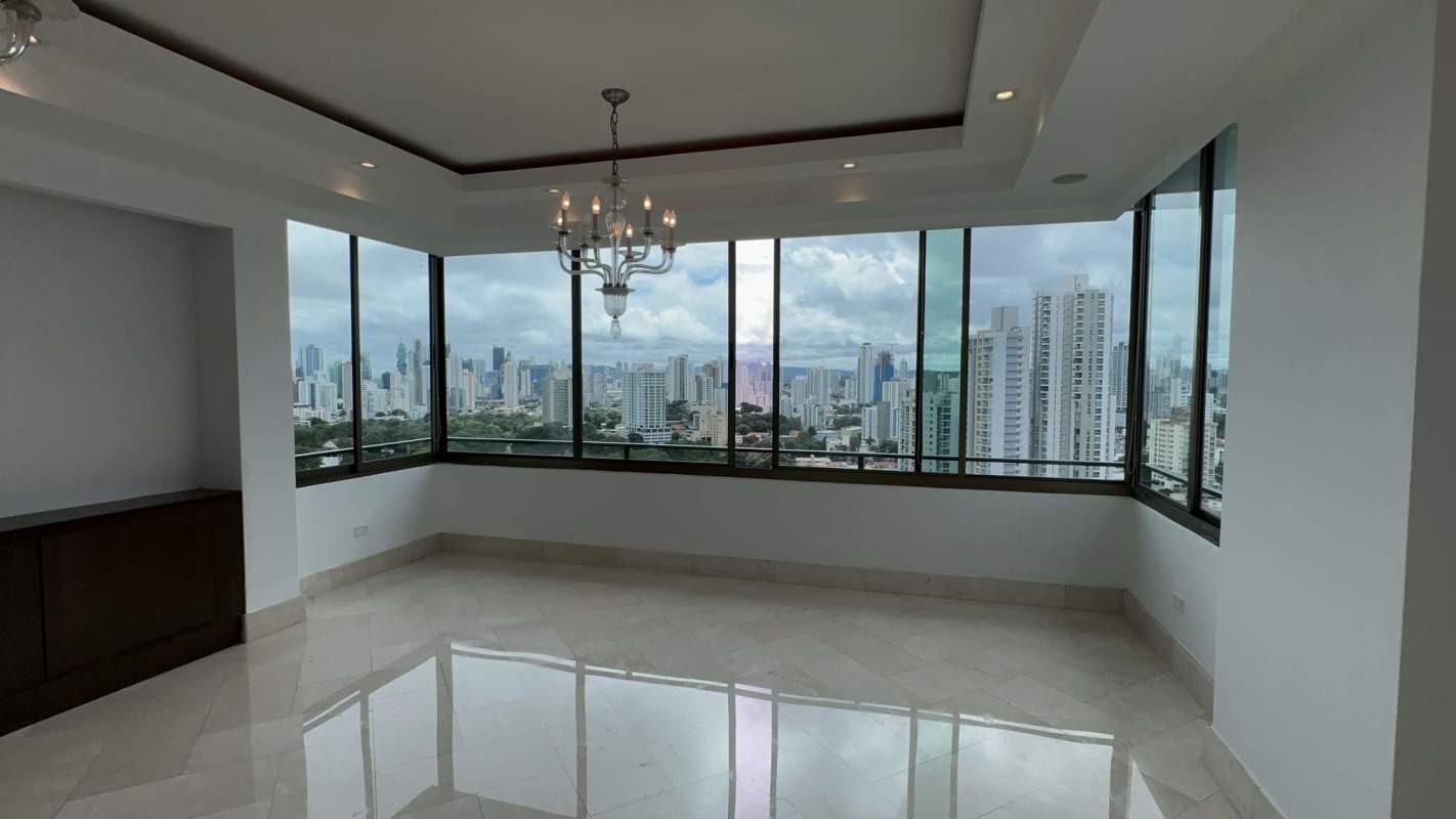 Modern interior with panoramic windows overlooking city skyline in Altos del Golf penthouse Panama City