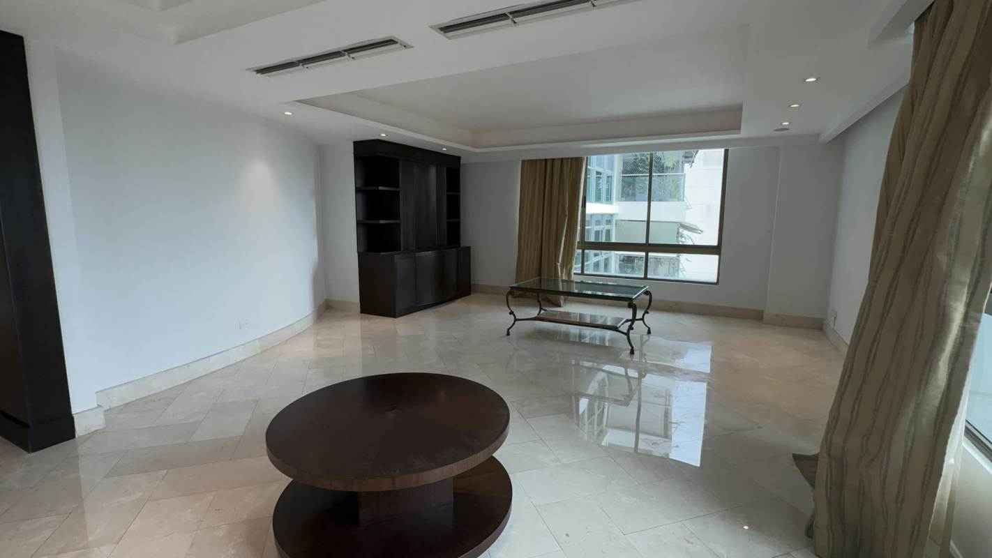 Spacious living room with marble floors, built-in shelves and large windows in penthouse Altos del Golf Panama