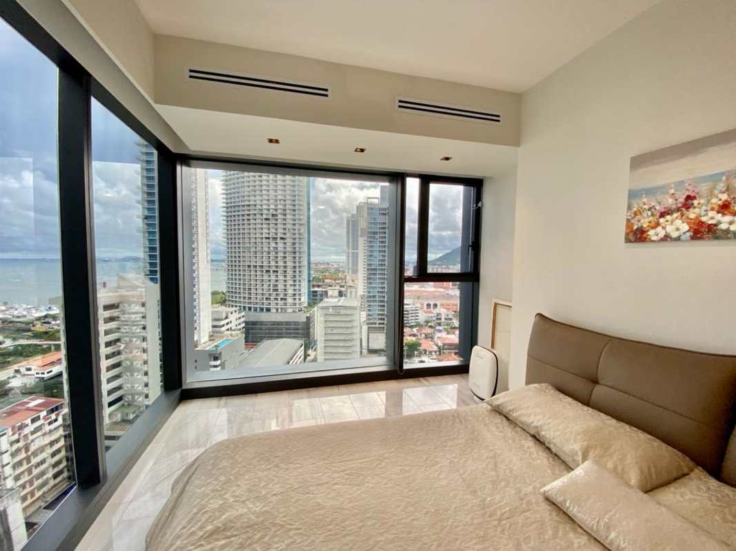 Modern open-plan living dining area with balcony ocean view at Nuovo by Armani Casa Panama City