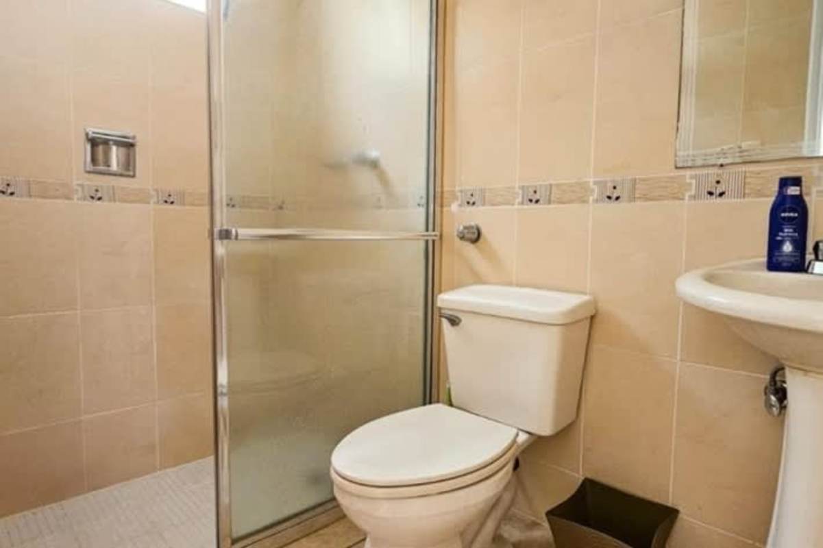 Bedroom with natural light, minimalist furnishings, tile floors in Brisas del Occidente house