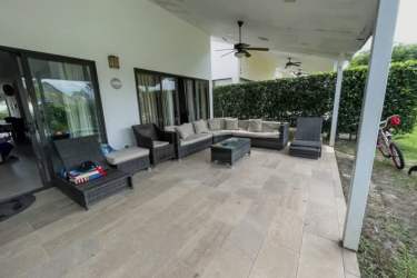 Covered backyard lounge seating beside pool in Punta Paraíso Coronado Panama