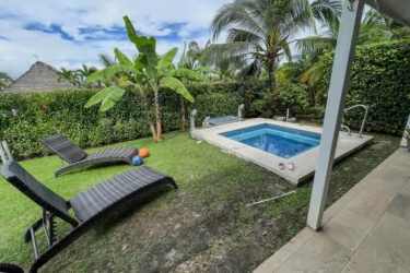 Small backyard pool surrounded by lush greenery and lounge chairs in Coronado beach house