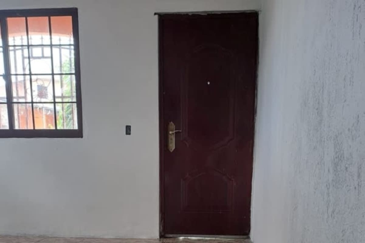 Narrow service area with brick wall, tiled floor, and faucet at La Siesta Tocumen house