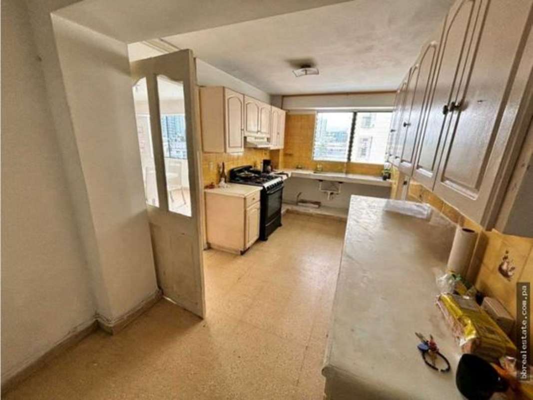 Traditional kitchen with gas stove, large window, cabinetry PH Vista del Este apartment Panama City
