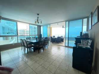 Swimming pool surrounded by lush gardens and palm trees at PH Playa Serena condominium Gorgona Panama