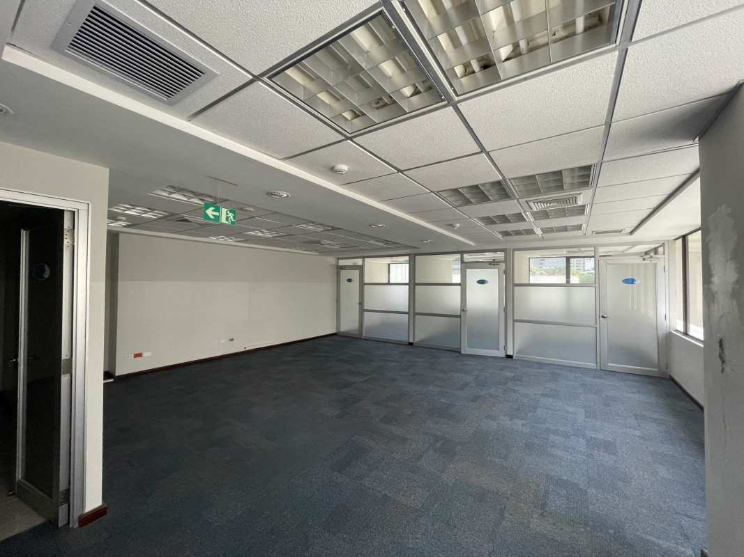 Empty modern office with carpet, suspended ceiling and emergency exit in Torre Canaima Obarrio Panama
