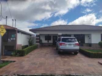 Modern kitchen with granite countertops and dark wood cabinets in Villa Patricia David Panama.