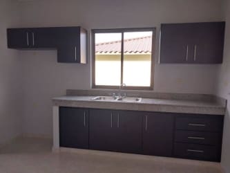 Contemporary bathroom with beige tiles, glass shower enclosure in new house Doral Villas David Panama