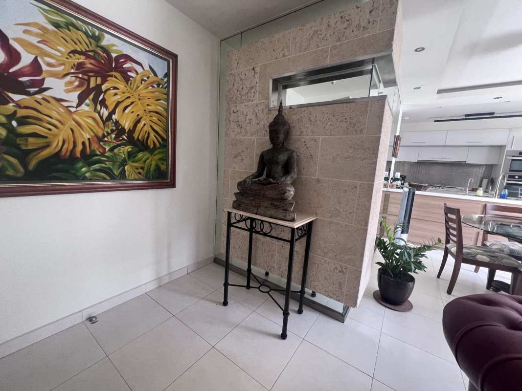 Modern open kitchen and dining with large artwork, Buddha statue, tile flooring Panama