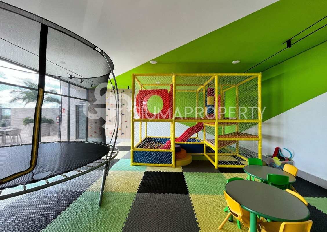 Colorful indoor playground with trampoline activity tables and large windows at Ocean House Panama