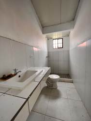 Simple white tiled bathroom in country home El Espavé de Chame