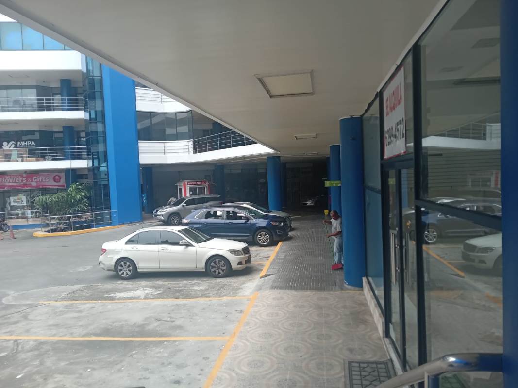 Modern commercial complex exterior with glass storefronts and ample parking lot along Tumba Muerto Panama