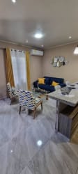 Modern living space with blue sofa, dining island, flat-screen TV in Villa Dora 2 apartment for rent David Panama