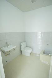 Simple white tiled bathroom with sink toilet inside commercial property at GDP Center Panama