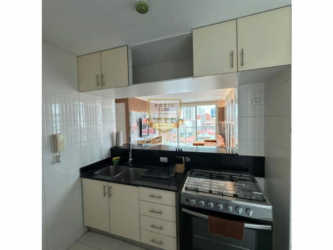 Black granite kitchen with gas stove and pass-through to living room Panama apartment for rent
