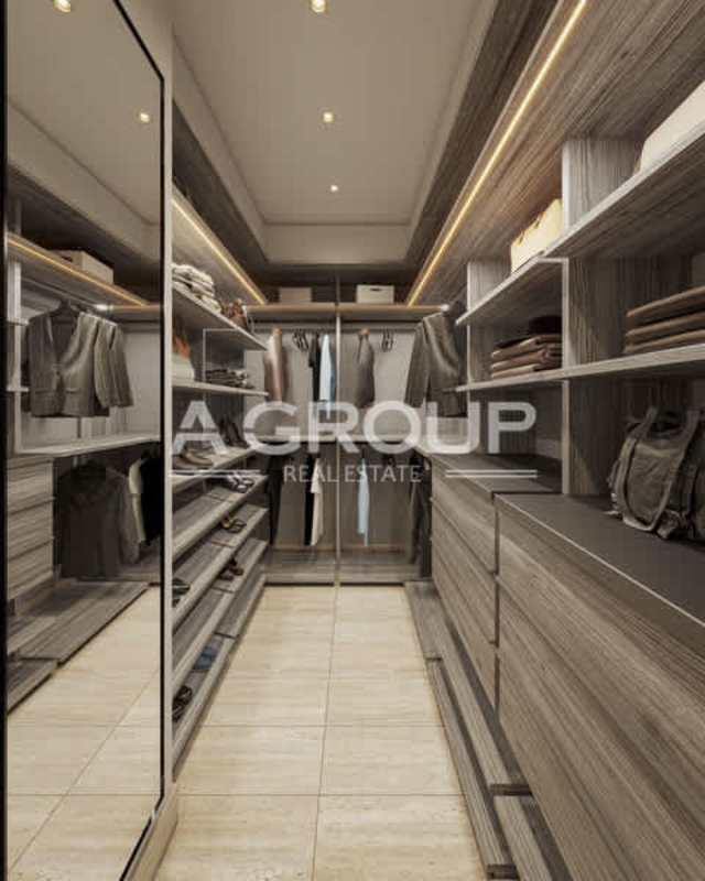 Walk-in closet with custom wood cabinetry lighting in luxury duplex Santa María Panama