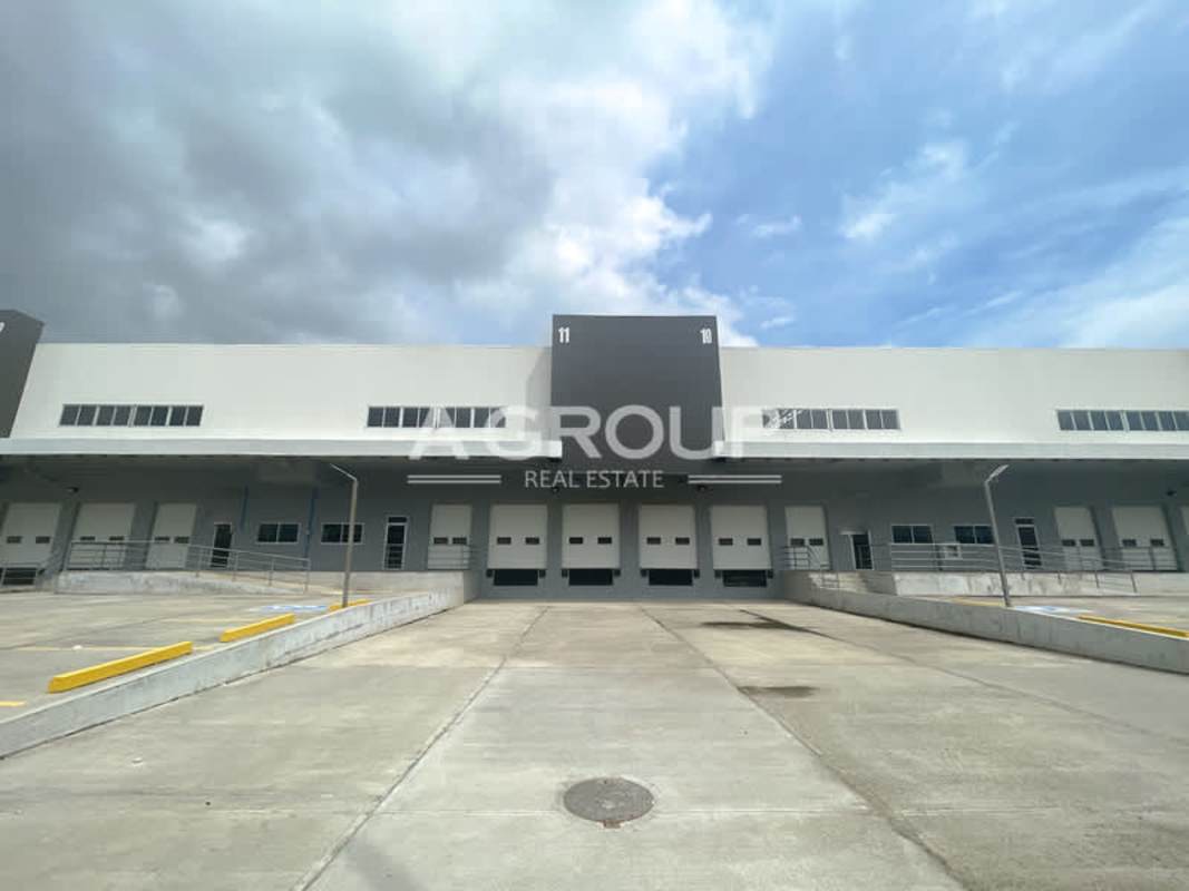 Front of warehouse with multiple container bays, parking spots, modern facade at Zona Uno Panama