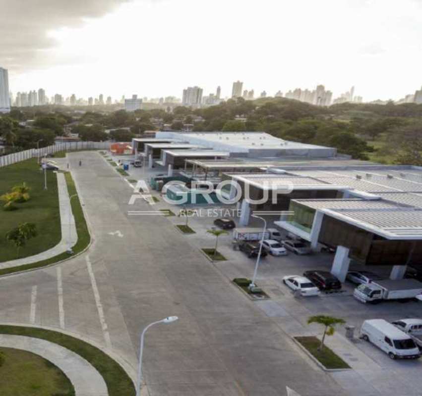 Modern commercial complex with parking, glass facades, city skyline at Panama Viejo Business Center