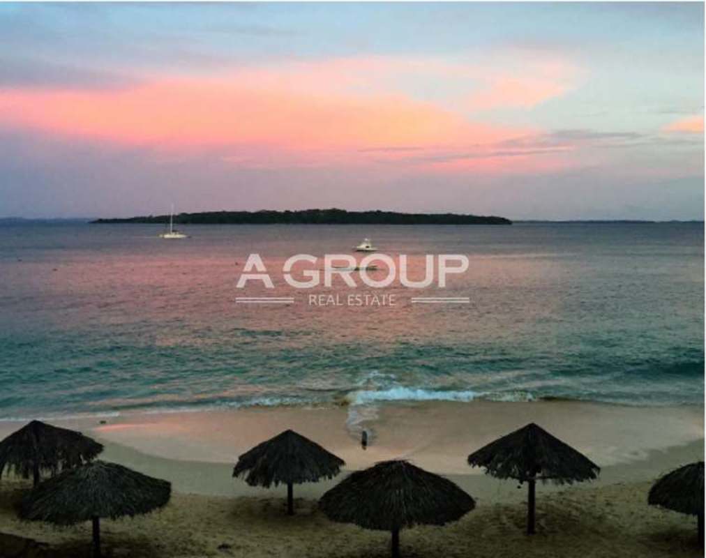 Golden sunset over sandy beach with pier rocky coastline Isla Contadora Panama