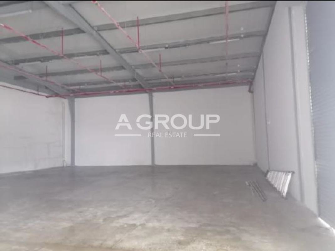 Empty interior of industrial warehouse with concrete floors, exposed steel beams, sprinkler system in Panama Viejo Business Center