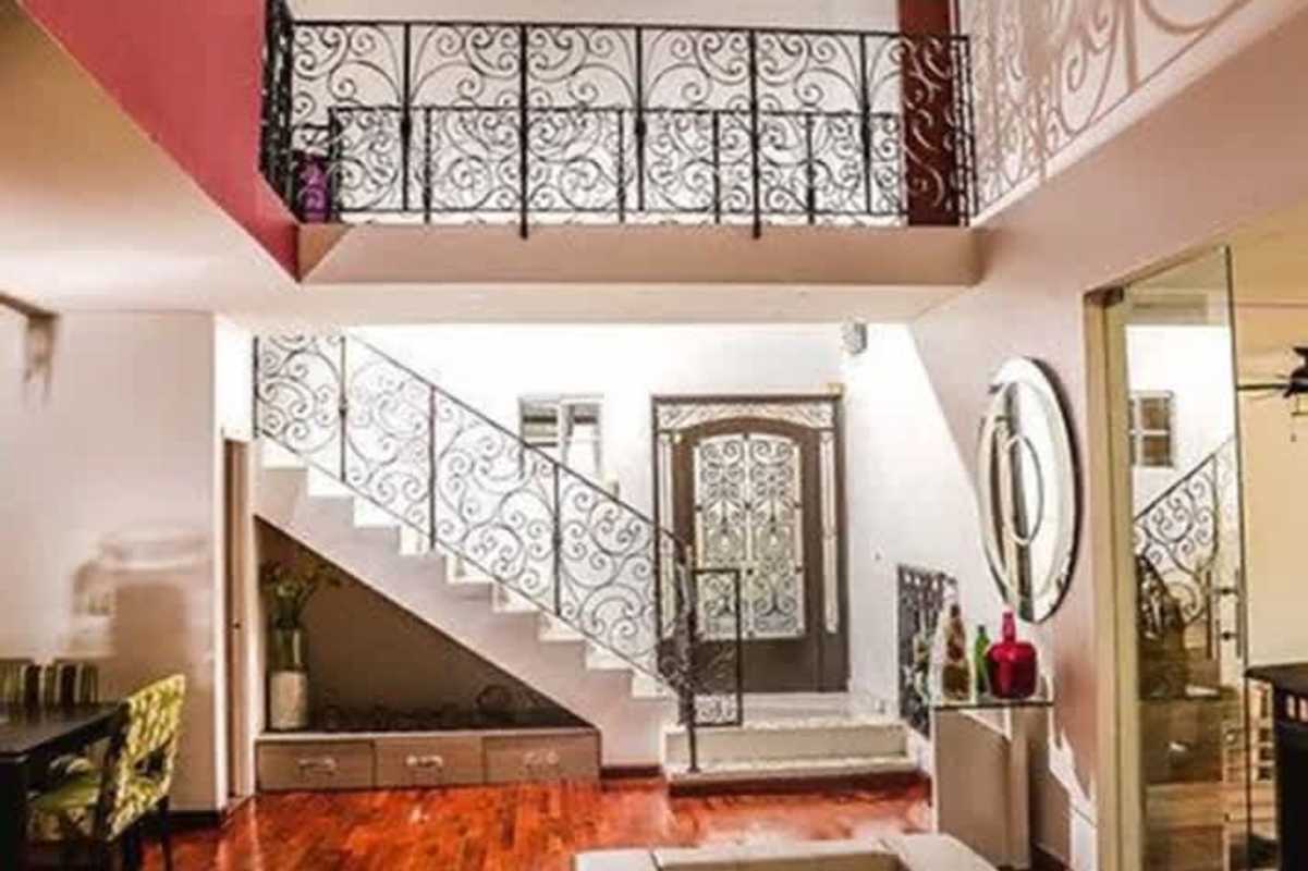 Double-height foyer with ornate staircase, wood flooring in a modern home Altos de Panamá Panama