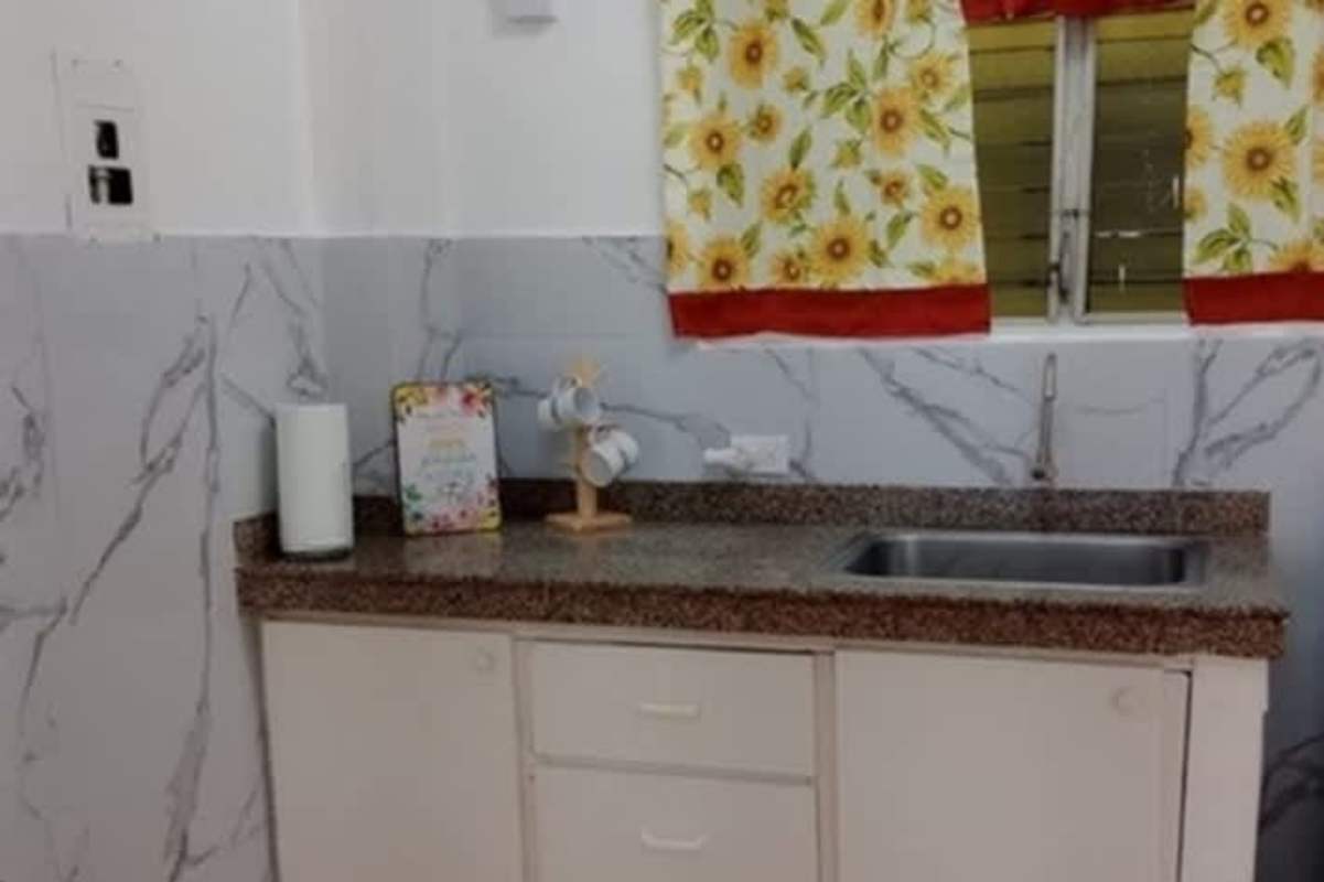 Kitchen with granite countertop, marble tile backsplash, stainless steel sink, sunflower curtain at PH Bella Vista Panama