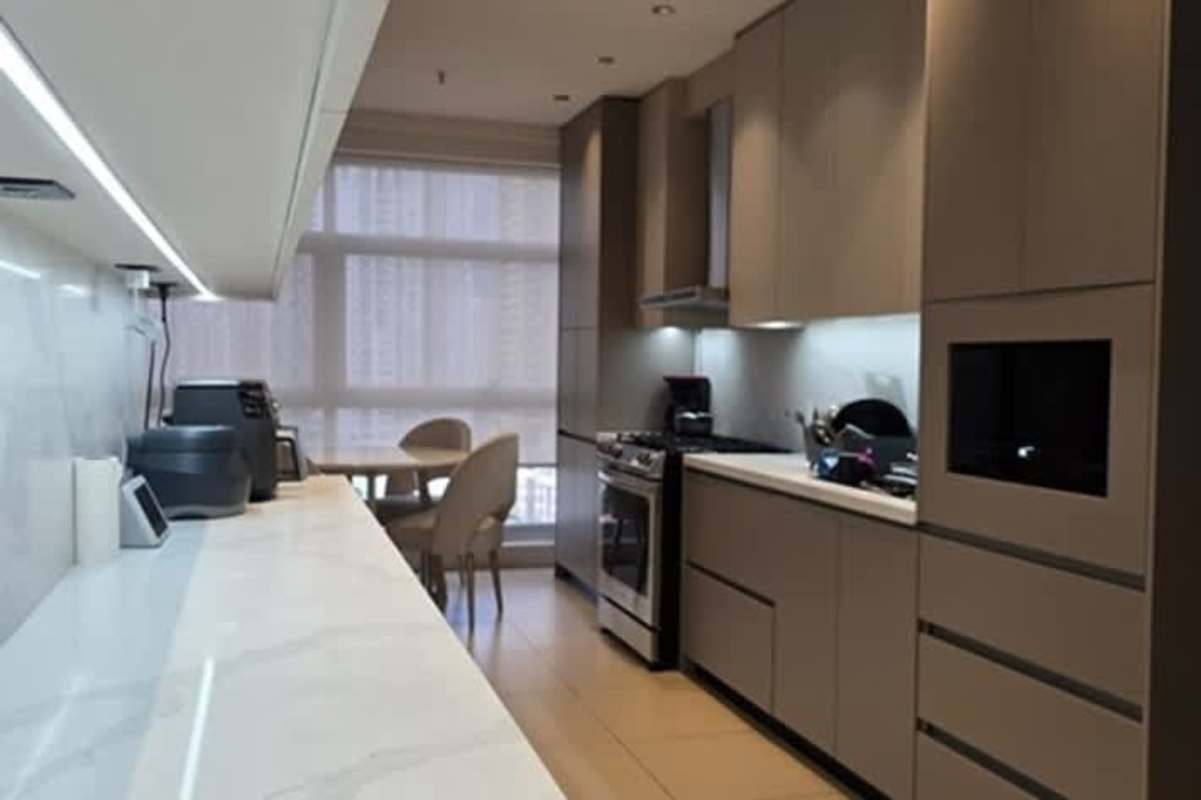 Bathroom with marble tiles vessel sink backlit mirror black fixtures PH Pacific Point Punta Pacifica