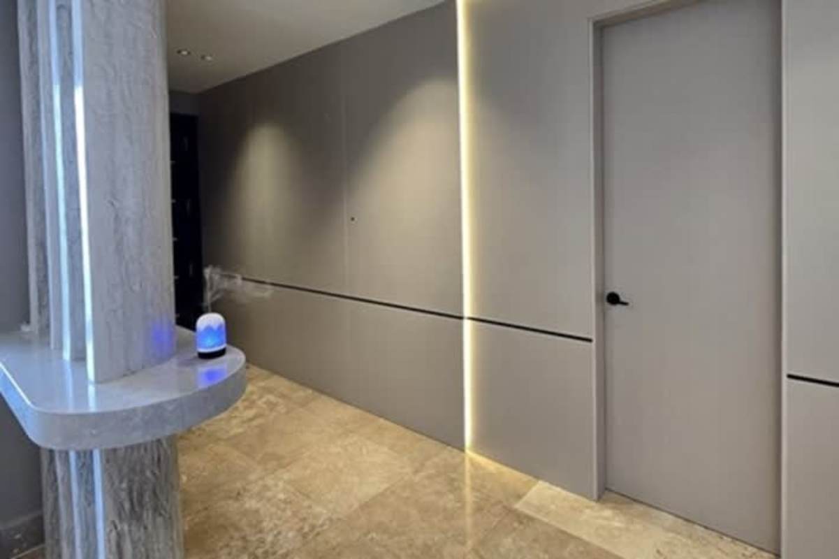 Minimalist hallway marble accents vertical LEDs and hidden door PH Pacific Point Panama