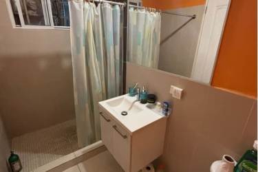 Covered laundry space with washer and hanging clothes at Montelimar house