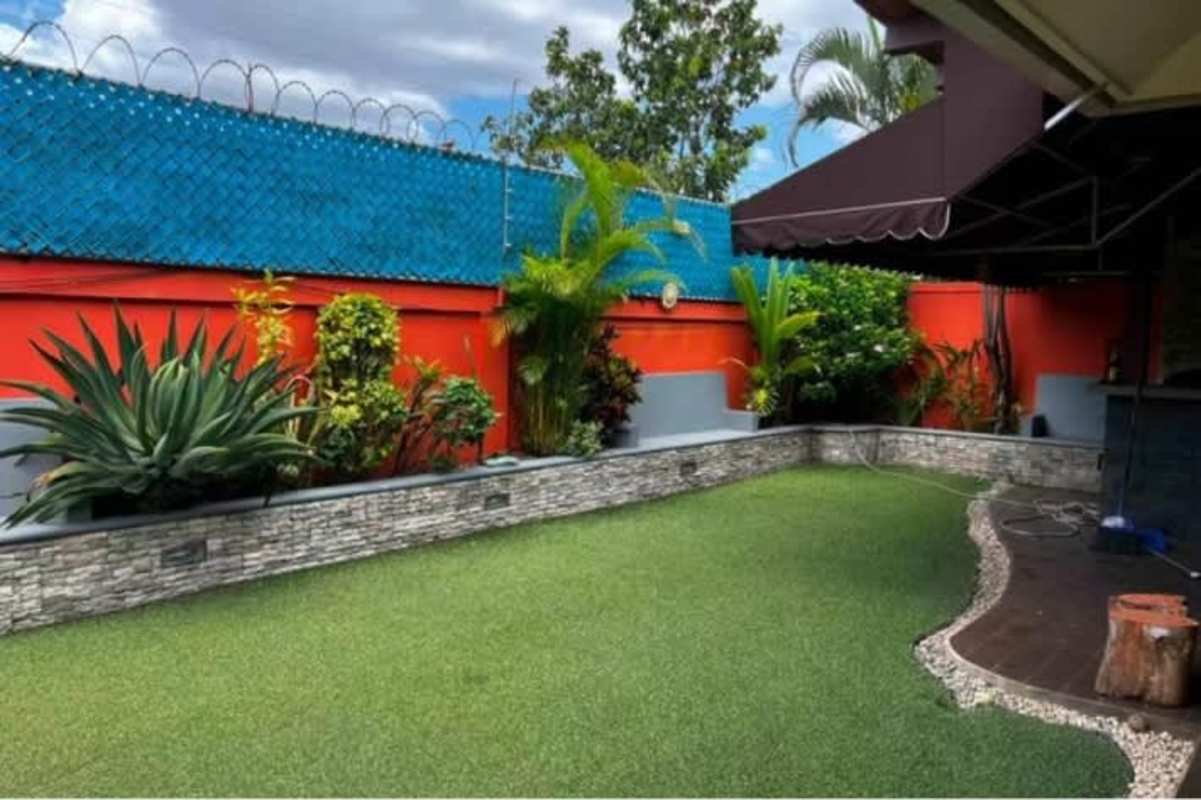 Covered patio with stone bar, seating area, colorful pillows at Campo Lindbergh Panama