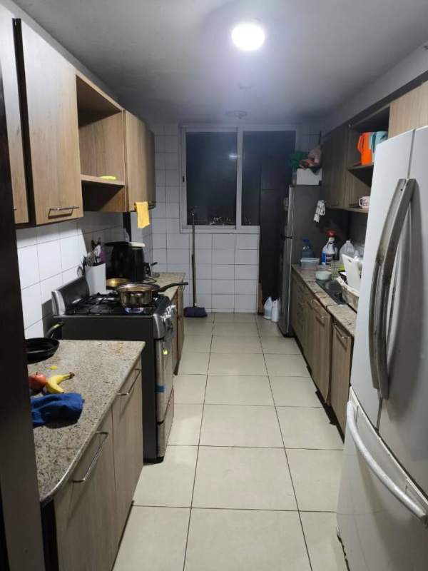 Kitchen with granite countertops, wooden cabinets, gas stove, refrigerator at PH King Park Panama