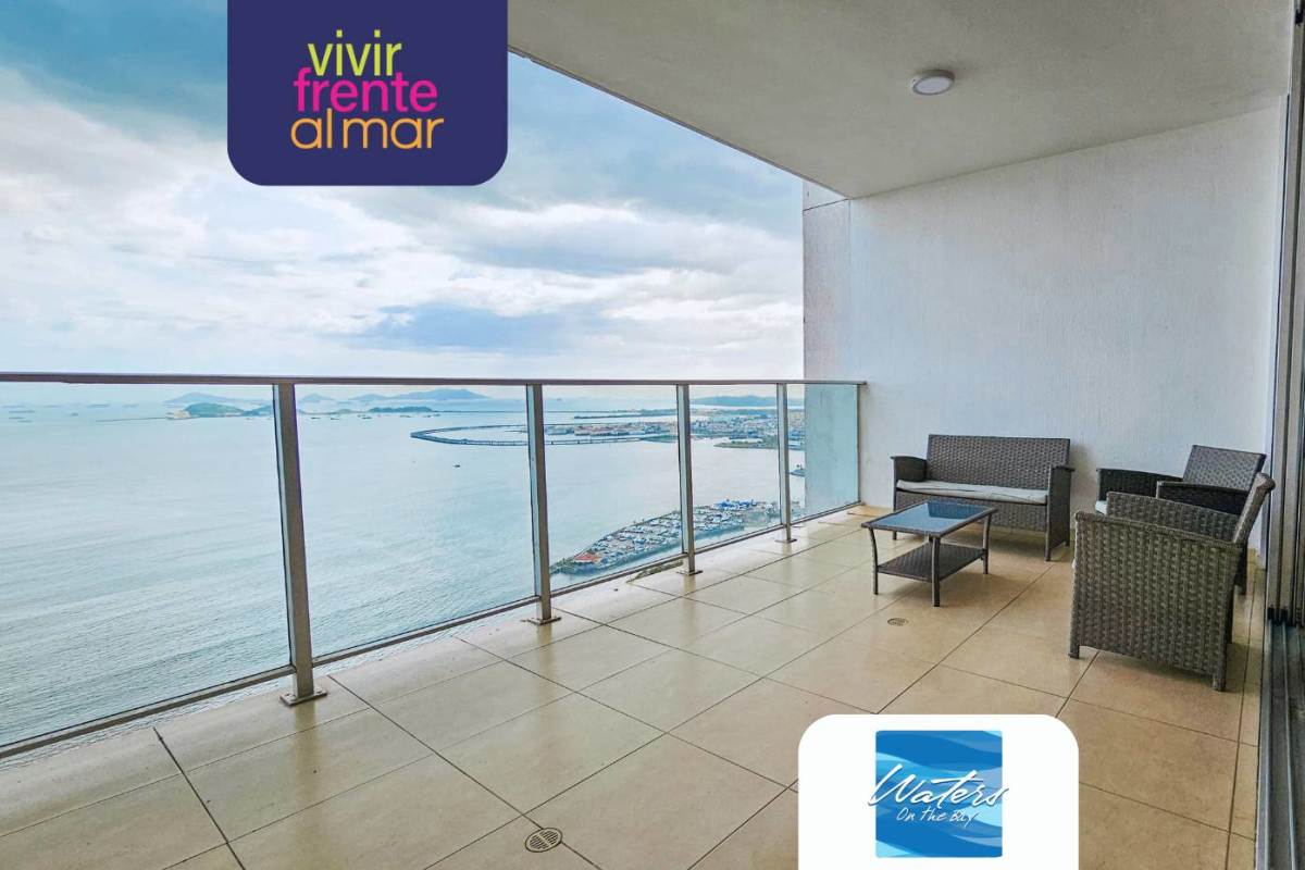 Spacious living room with large windows and balcony access overlooking the ocean at Waters on the Bay Panama City