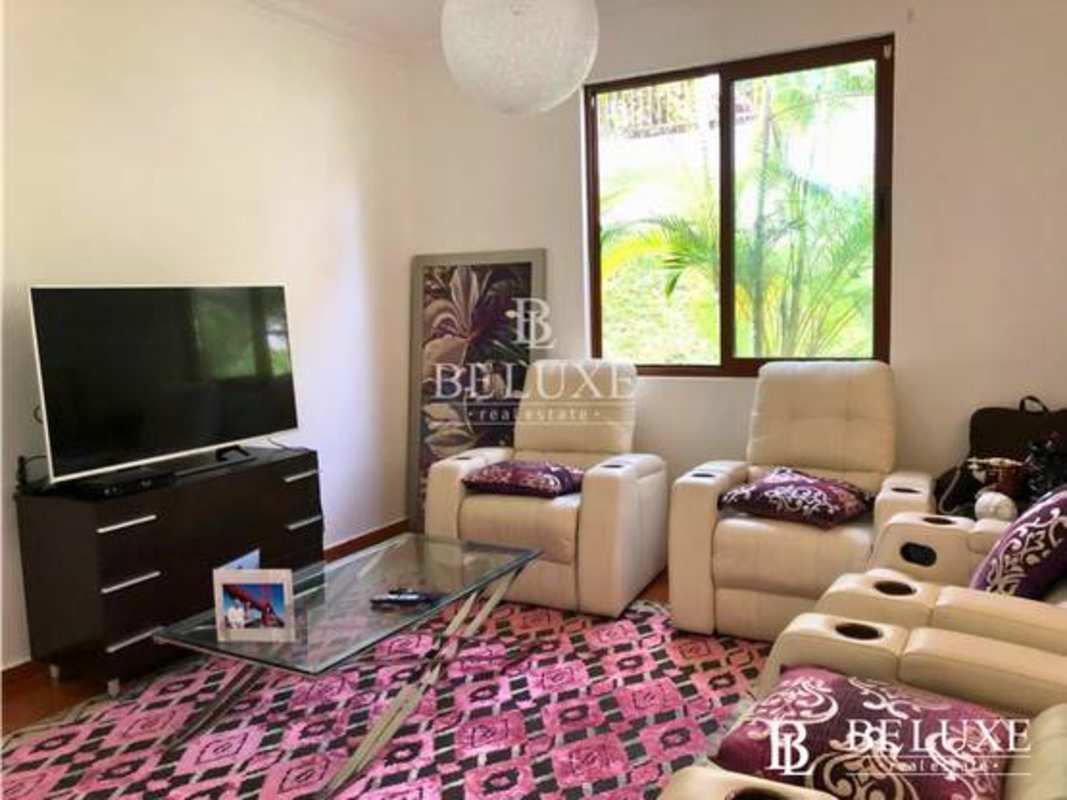 Covered outdoor lounge with terracotta floor and stone columns Panama home