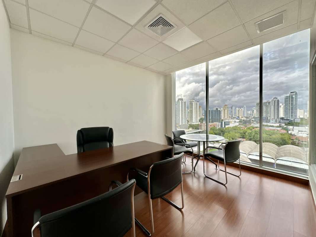Modern conference room with glass table and mesh chairs Office One Panama City