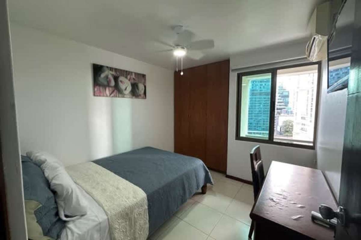 Modern living room with sectional sofa, balcony access, ceiling fan and panoramic view Punta Pacifica Panama