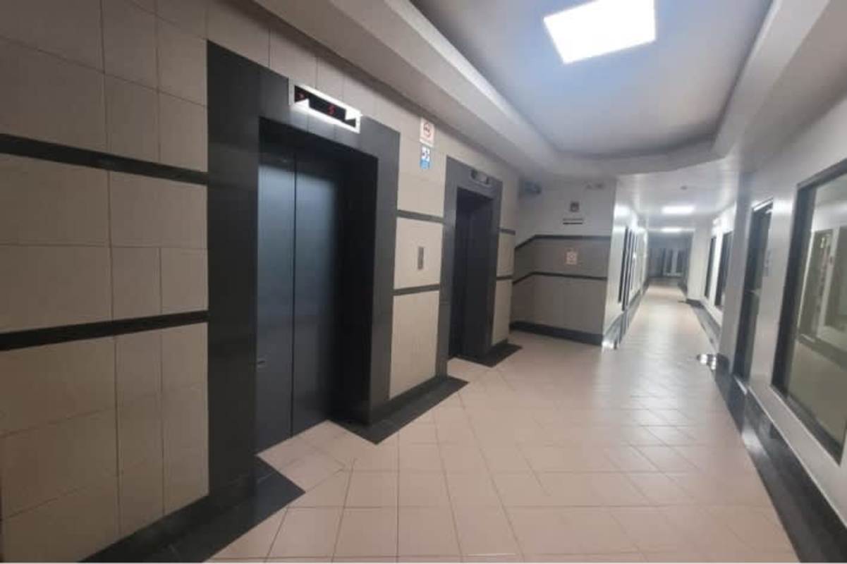 Modern office room with built-in L-desk, frosted glass cabinets and glass door in El Dorado Panama City