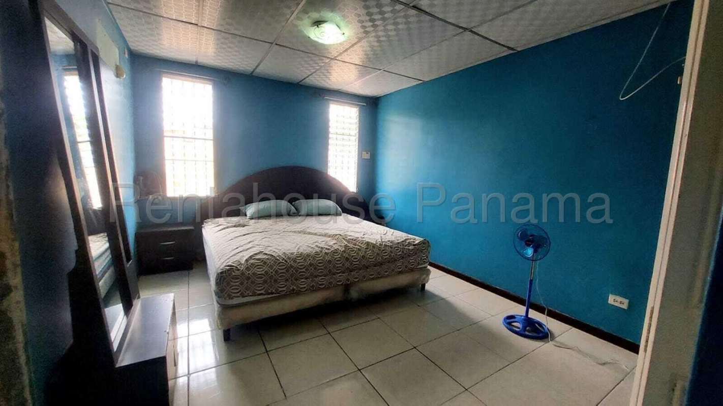 Bright living room with ceramic tile floors, ceiling fan, split AC in duplex house for sale in Condado del Rey Panama