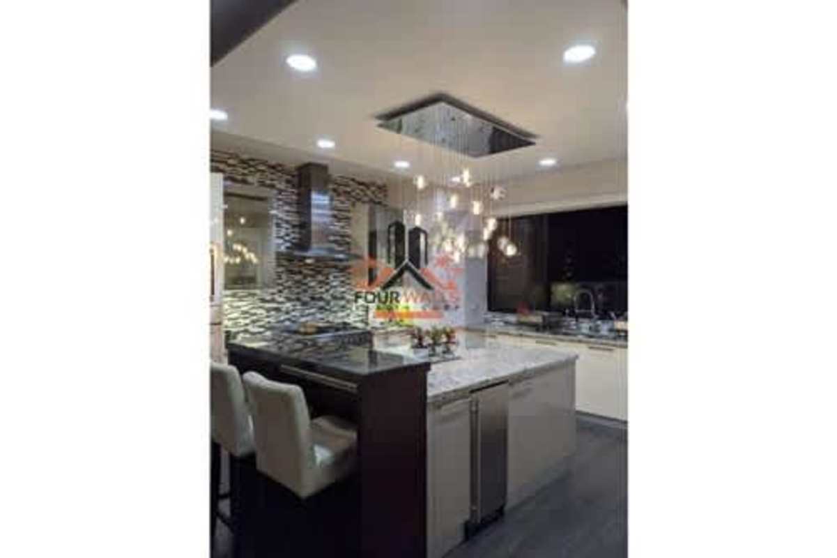 Spacious Italian kitchen with large island, mosaic backsplash, pendant lighting, and high-end finishes in luxury Punta del Sol apartment