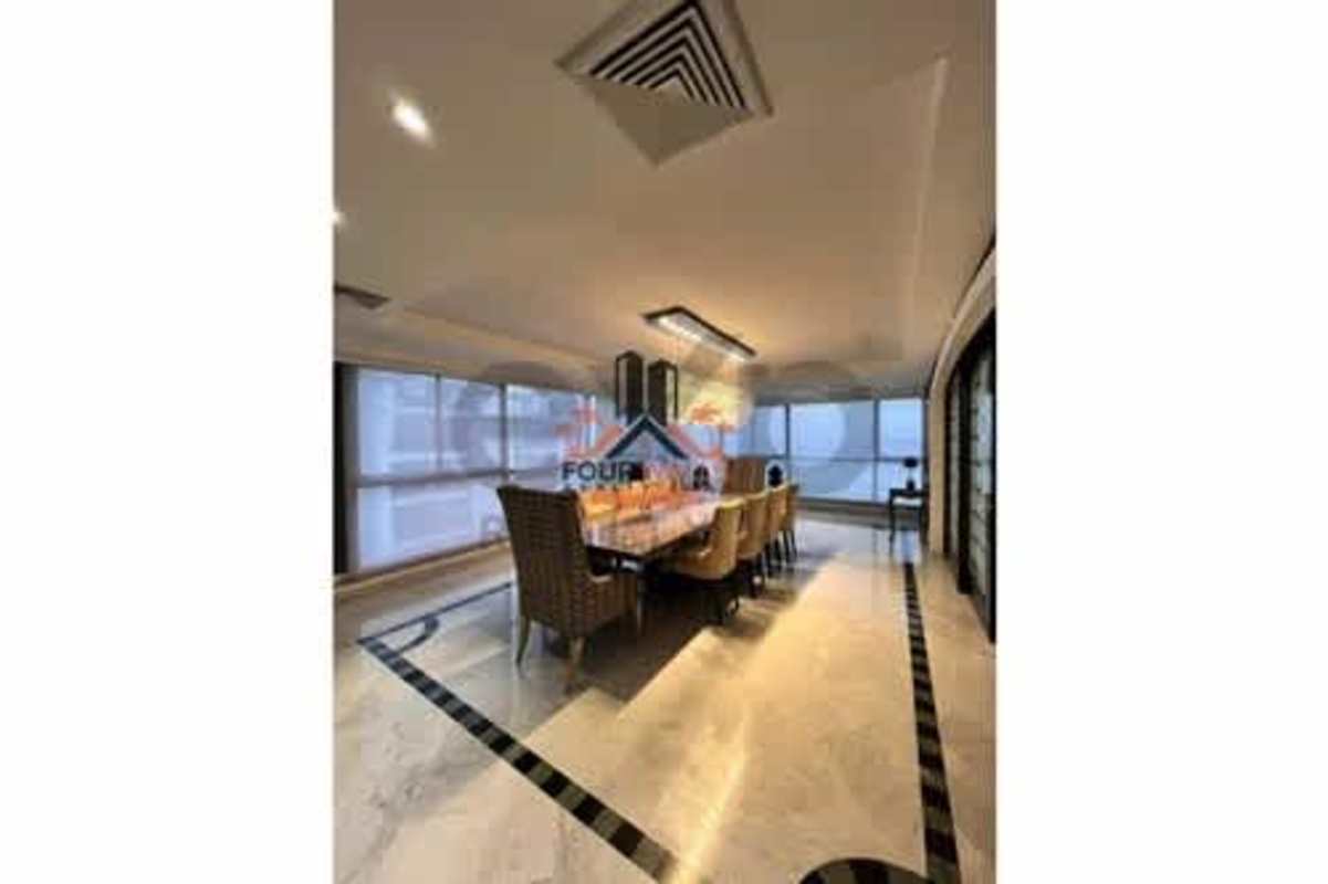 Modern dining area with chandelier, marble floor, floor-to-ceiling windows overlooking Panama City skyline at PH Punta del Sol