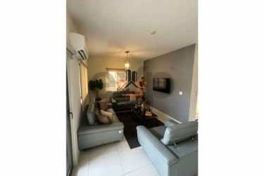 Spacious living room with gray sofas TV and glass sliding doors in Panama Pacifico